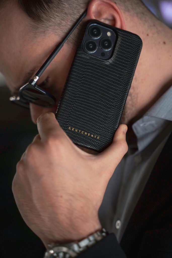 Close-up of a man using a luxury leather phone case, embodying style and modern technology.